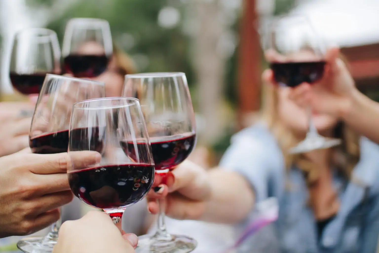 Several people raising their wine glasses in cheers