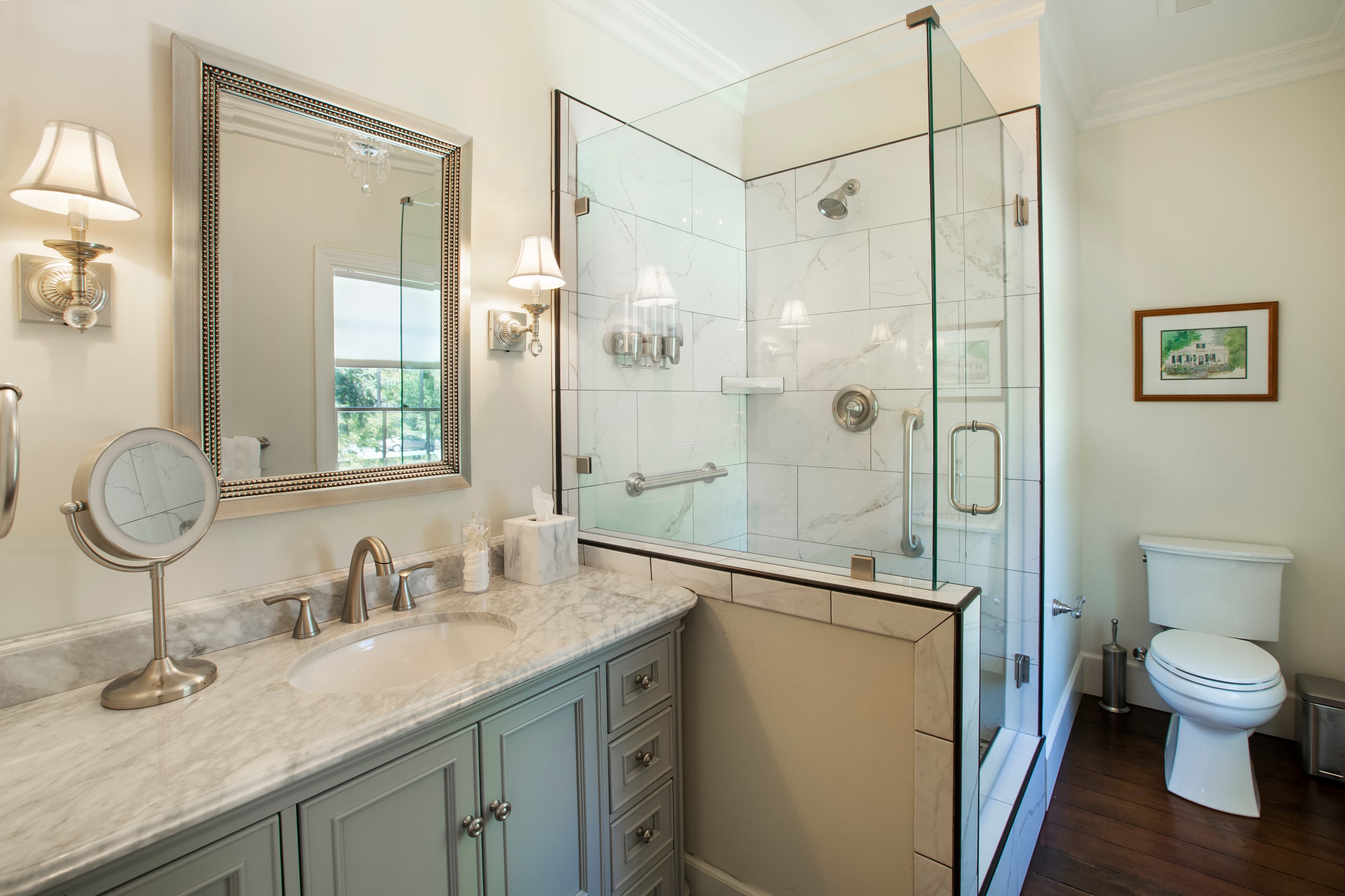 Modern bathroom with a shower, marble countertop, and elegant lighting.