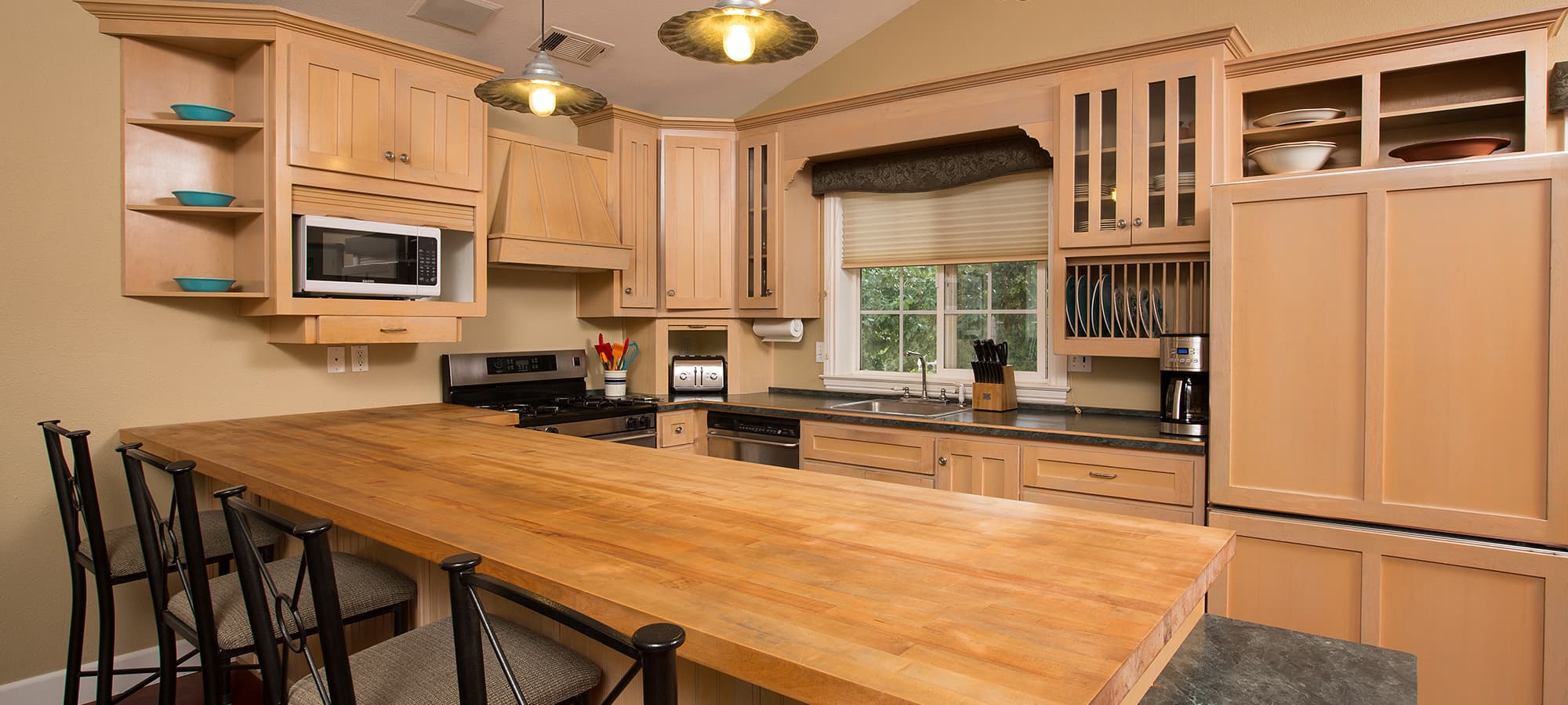 Light-filled kitchen with wooden countertops and modern appliances.